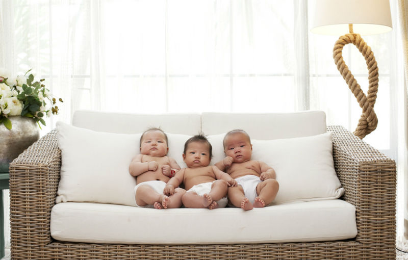 ゆったりしたソファに座る３人の赤ちゃん