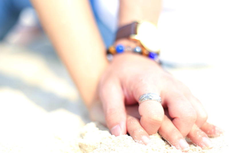 砂浜で手を絡め合うカップル