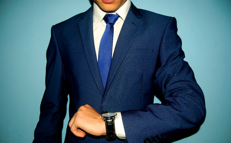 腕時計を見るスーツ姿のビジネスマン